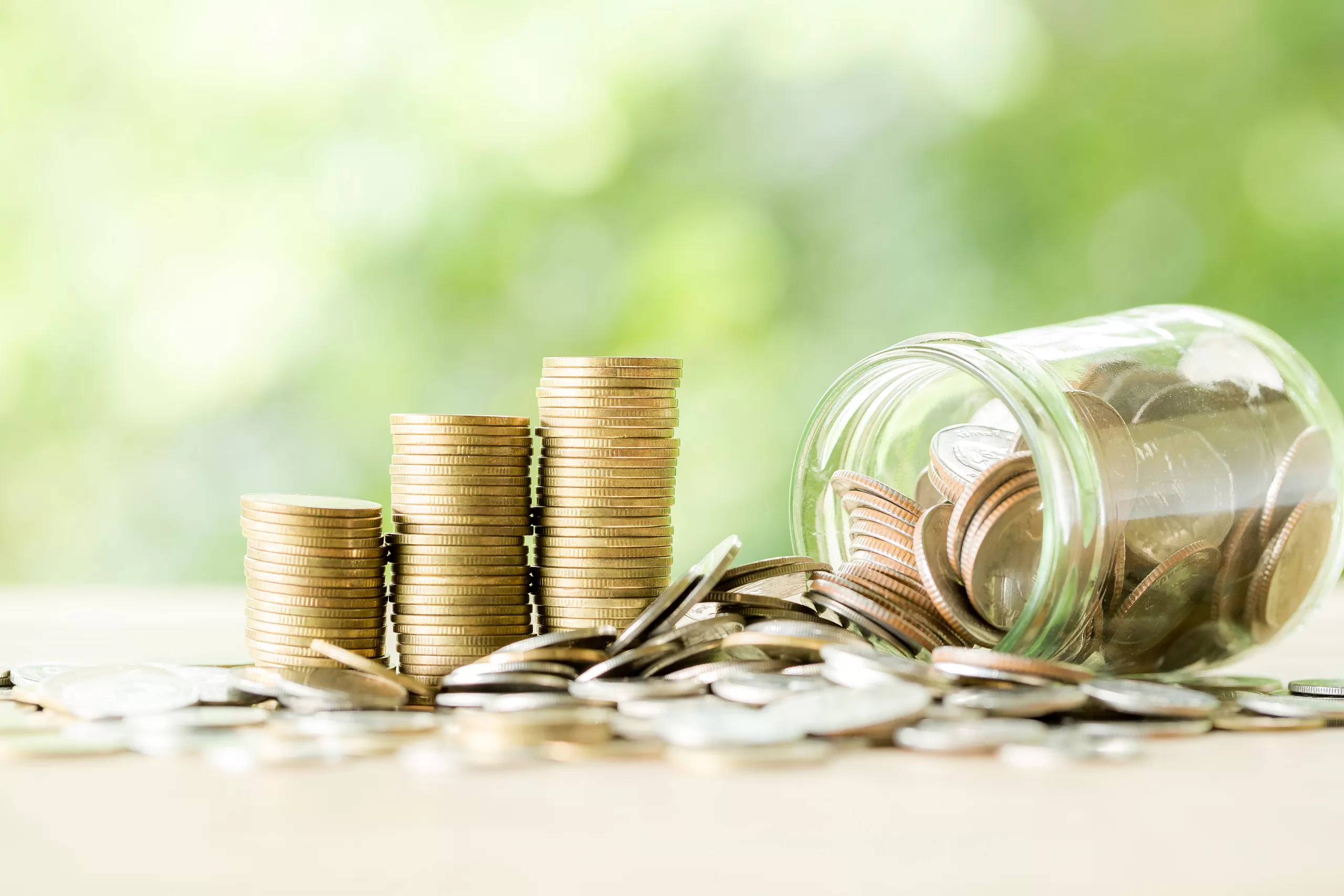 Coin on wooden table in front of green bokeh background. coins a concept of investment and saving moneys.